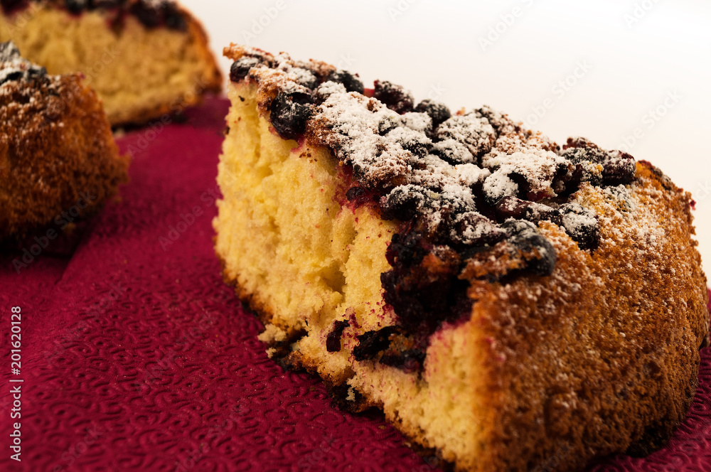 Obraz na płótnie A slice of homemade baking with berries on a bard napkin on a white background