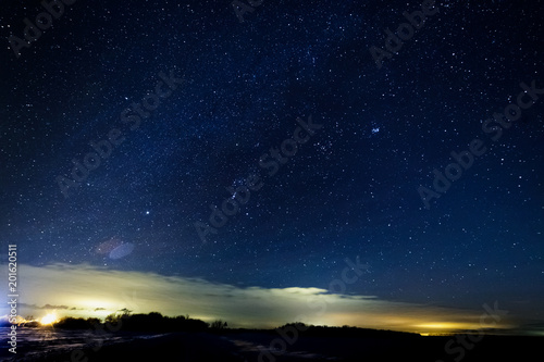 Starry sky above the clouds. Clouds are illuminated by lanterns.