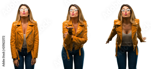 Beautiful young woman expressing love  blows kiss at camera  flirting over white background