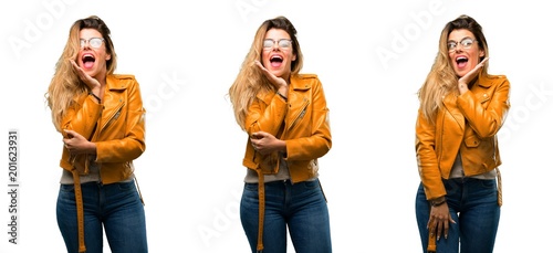 Beautiful young woman happy and surprised cheering expressing wow gesture over white background
