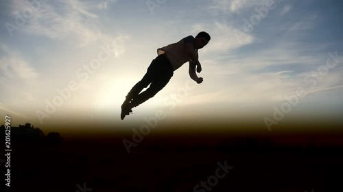 Man Parkour tricker jumper performs amazing flips, silhouette photo