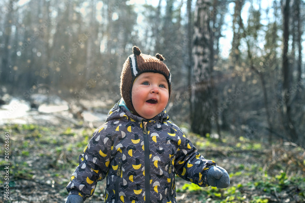 The child emotionally plays with a twig, magic and charm in the forest. Forest without leaves in spring or autumn. The child emotionally plays with a twig, magic and charm in the forest. Forest without leaves in spring or autumn.