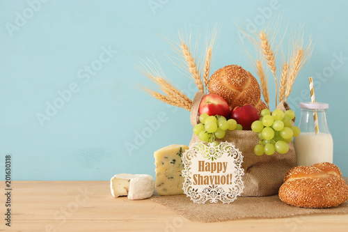 image of fruits  bread and cheese in the basket over wooden table.