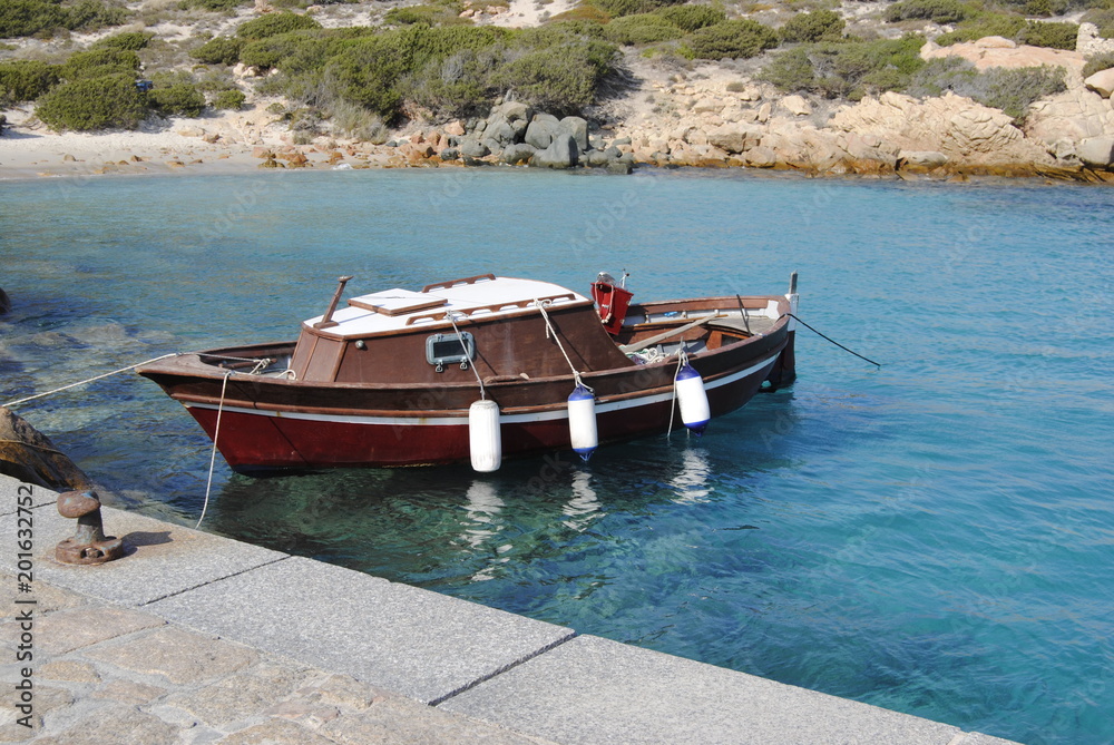 Obraz premium Barca amarrada en una cala de la ISla de CErdeña, Costa Esmeralda, Italia