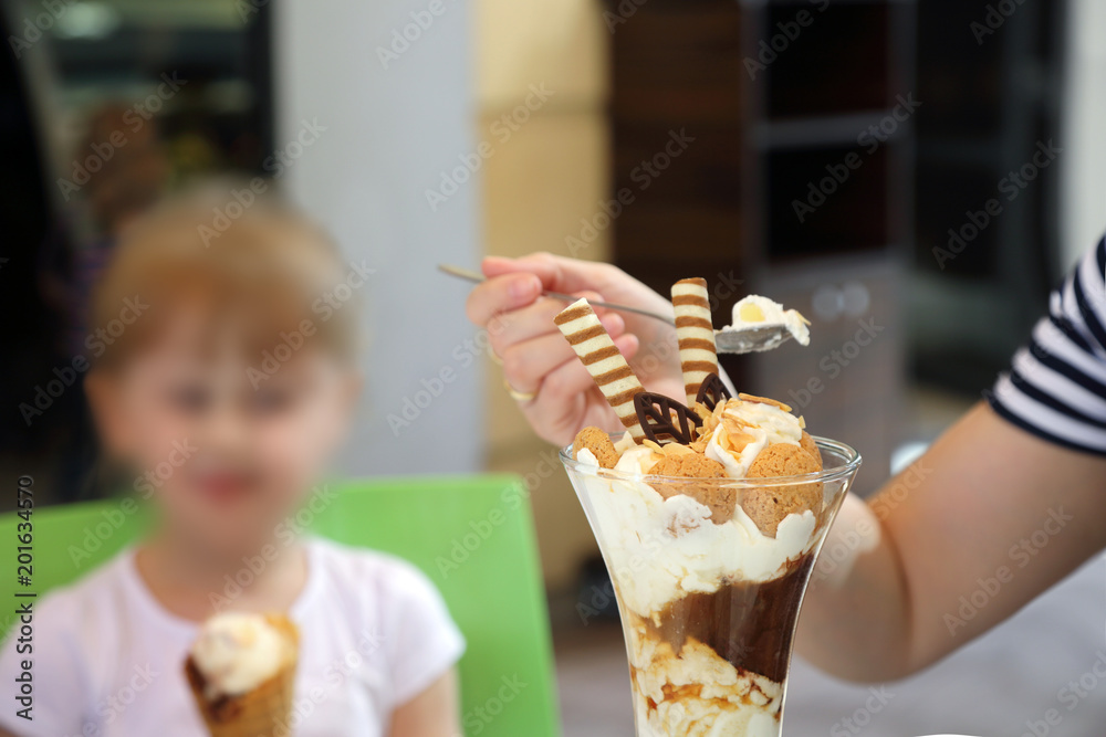 Matka z córką jedzą smaczne i piękne lody. - obrazy, fototapety, plakaty 