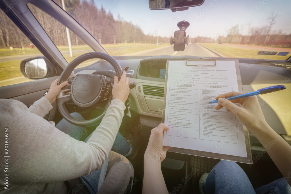 Fototapeta premium Examiner filling in driver's license road test form