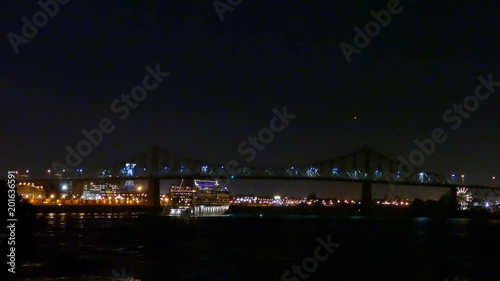 Luxury cruise ship lit up at night and navigating towards bridge photo