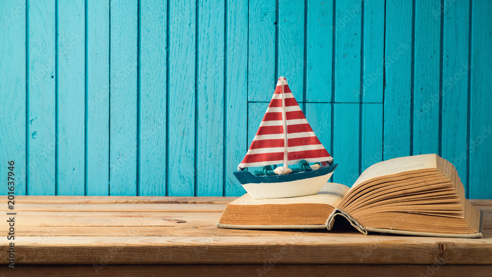 Obraz premium Boat and book on wooden table