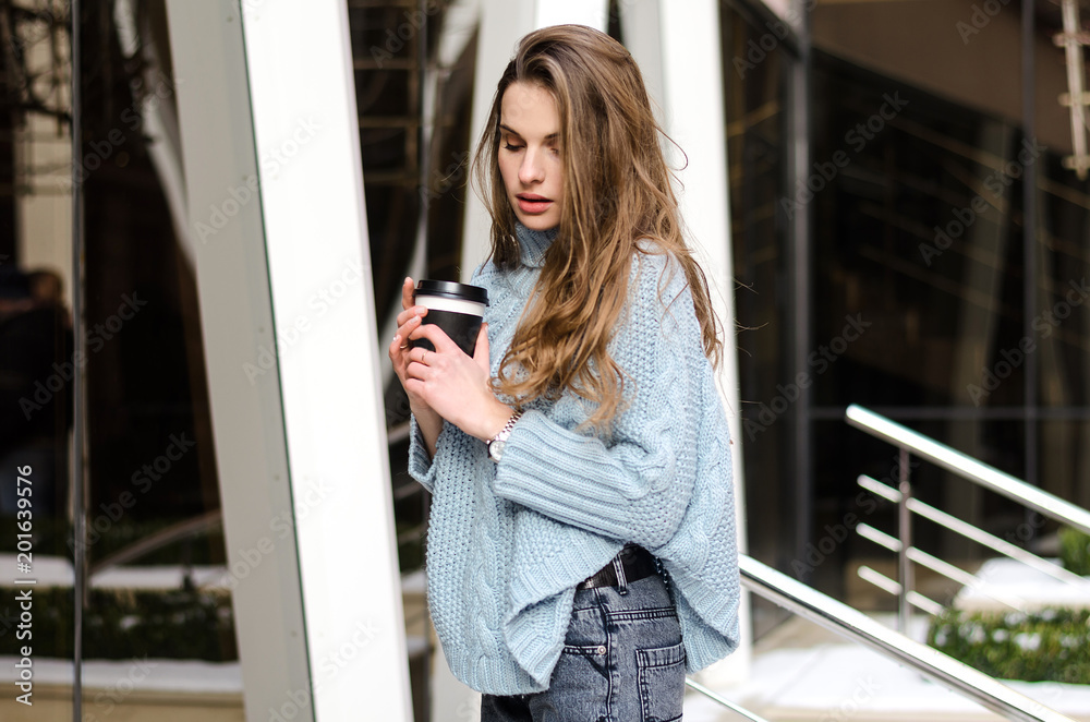 Fototapeta premium Young attractive lady with long curly hair with coffee to go, wearing stylish clothes 