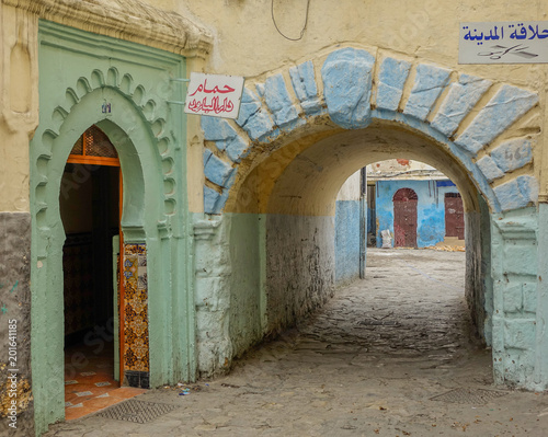 Tanger, Morocco, Africa - February 9, 2016: Street and passageway in the Medina of Tangier. Light green entrance and a blue facade on the other side of the passage