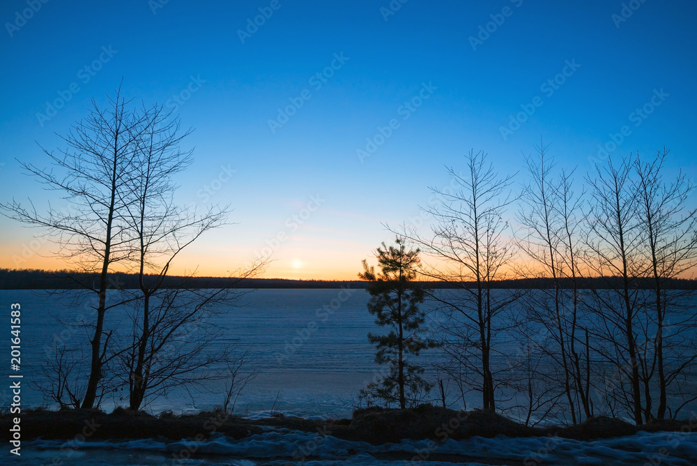 Frozen lake in the forest at sunset in the spring. Frozen lake in the forest at sunset in the spring.