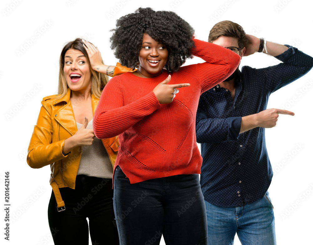 Group of three young men and women pointing away side with finger