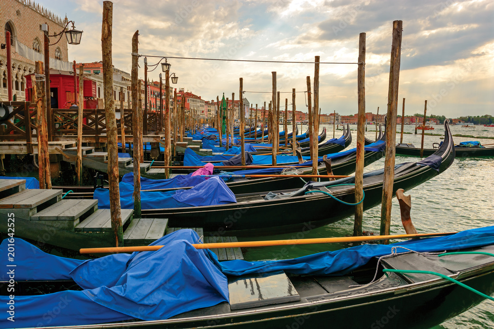 Gondolas at berth, Venice. Perspective view along anchored gondola's row