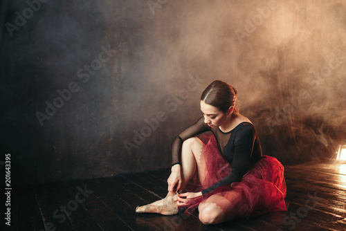 Ballet dancer tying pointe shoes