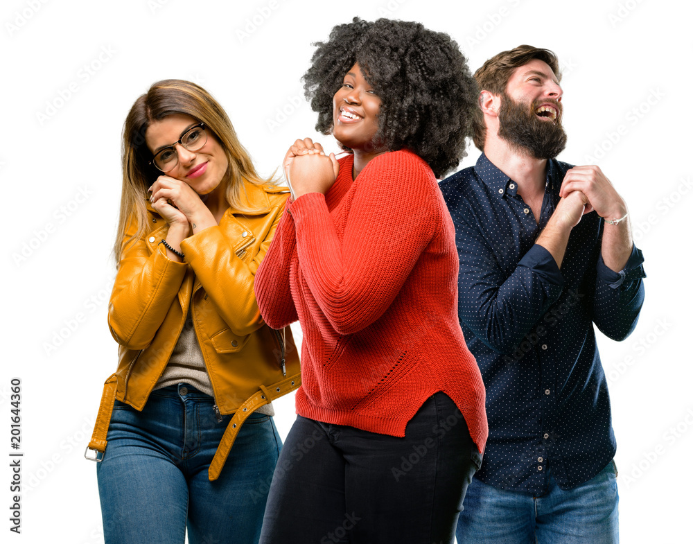 Group of three young men and women confident and happy with a big natural smile laughing Group of three young men and women confident and happy with a big natural smile laughing