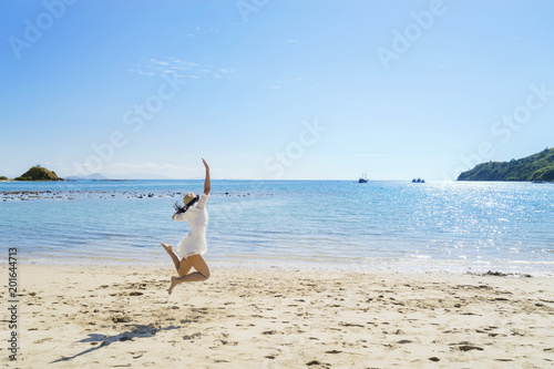 Young woman jumping on the tropical beach