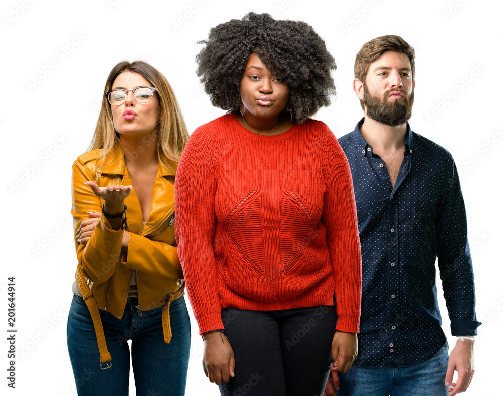 Group of three young men and women expressing love, blows kiss at camera, flirting Group of three young men and women expressing love, blows kiss at camera, flirting