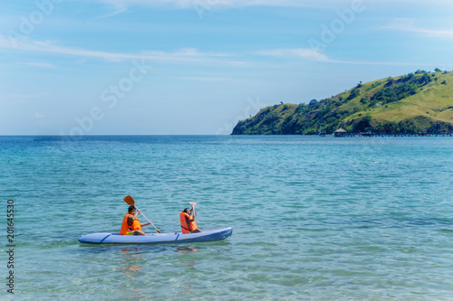 Two little children canoeing at tropical beach © Creativa Images