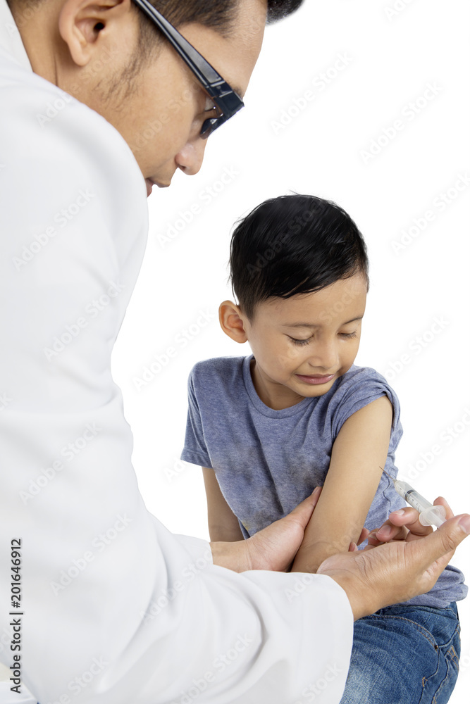 Little boy receiving a vaccine injection on studio Little boy receiving a vaccine injection on studio