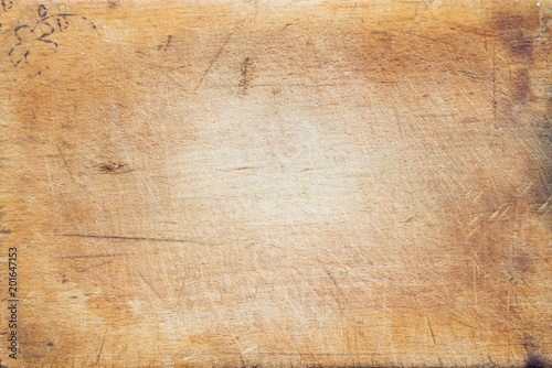 A textured wooden cutting board. Close-up view from top. Free space for text.