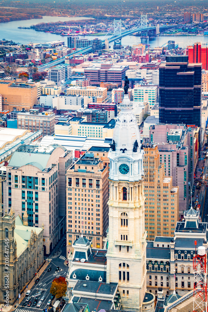 Fototapeta premium Aerial Philadelphia cityscape with the City Hall tower in the foreground and Ben Franklin bridge spanning Delaware river in the back