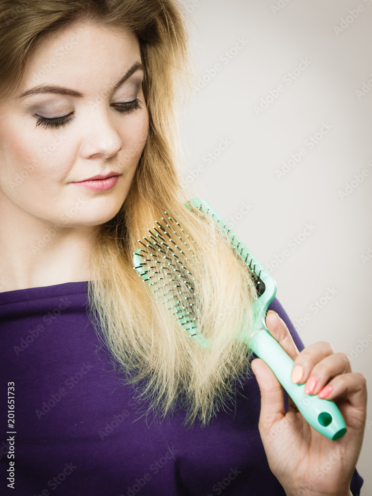 Obraz premium Woman brushing her long hair with brush