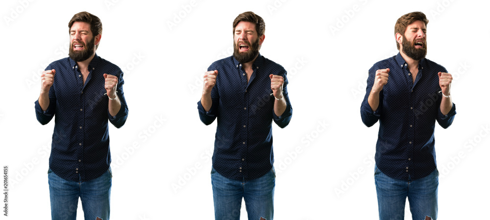 Young man with beard happy and surprised cheering expressing wow gesture isolated over white background