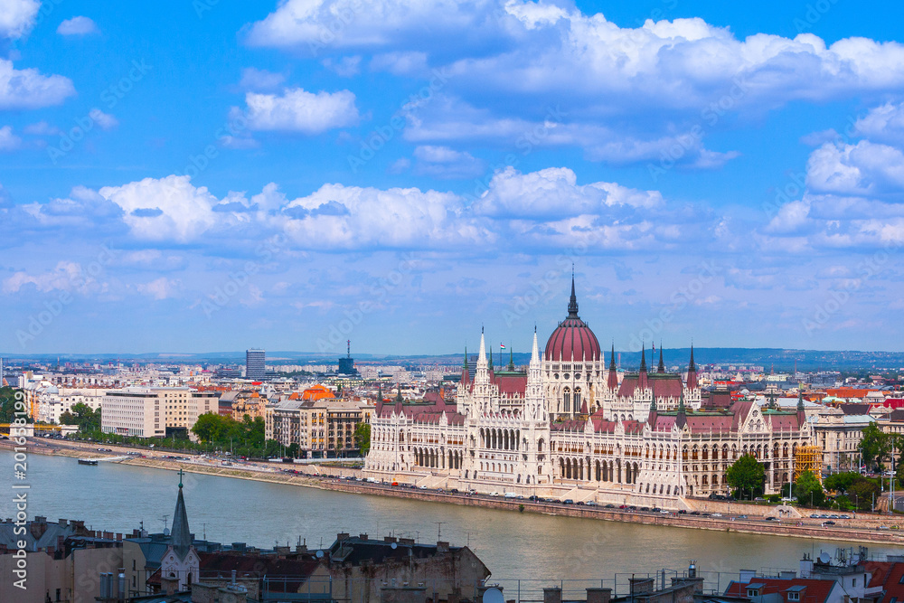 Panoramic cityscape view of hungarian of the Parliament - is currently the largest building in Hungary. Beautiful gothic and renaissance architecture style. Summertime sunny day in Budapest, Hungary.