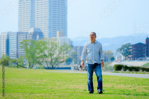 芝生の上を歩くシニア男性