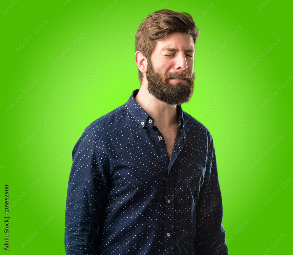 Young hipster man with big beard with sad and upset expression, unhappy over green background Young hipster man with big beard with sad and upset expression, unhappy over green background