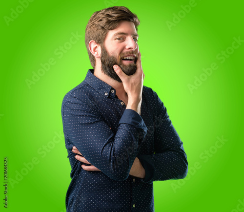 Quadro em tela Young hipster man with big beard happy and surprised cheering expressing wow ges