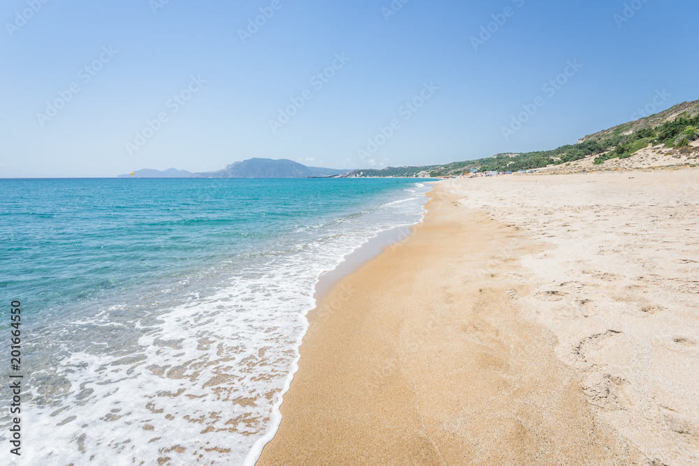 Beautiful sunny coast view to the greek mediterranean blue sea with crystal clear water and pure sandy beach empty place with some mountains rocks surrounded, Kefalos, Kos Island, Dodecanese, Greece