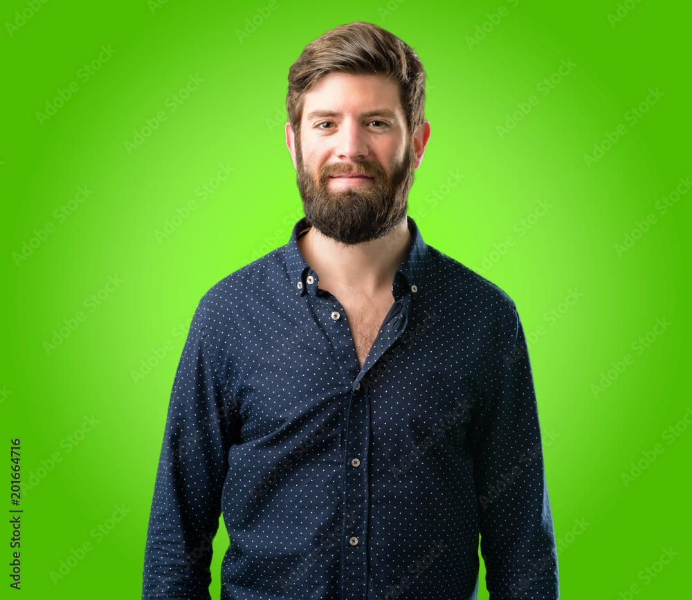 Fototapeta premium Young hipster man with big beard confident and happy with a big natural smile laughing over green background
