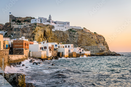Fototapeta Naklejka Na Ścianę i Meble -  Beautiful sunset sunrise coast view to old ancient monastery church on a cliff of mediterranean greek village Mandraki, Monastery of Panagia Spiliani, Nisyros Island, Kos, Dodecanese, Greece 