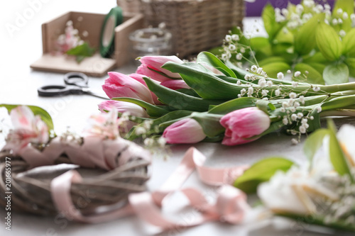 Decorator s workplace with unfinished wreath and beautiful flowers