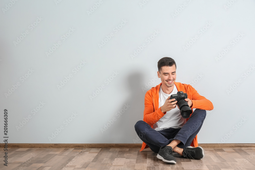 Male photographer with camera near light wall Male photographer with camera near light wall