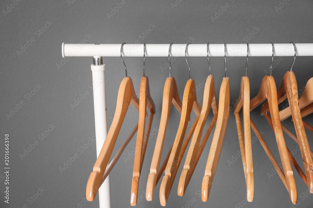Clothes rail with wooden hangers on gray background Clothes rail with wooden hangers on gray background
