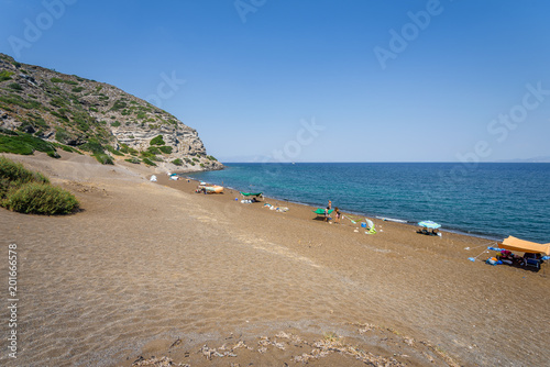 Sunny beautiful summer coast view to the greek blue sea white pure dark brown sand perfect for holiday relaxing swimming playing , Pachia Ammos Beach, Kos, Nisyros Island, Dodecanese/ Greece photo