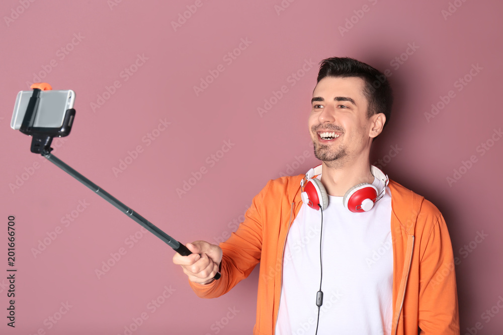 Handsome man taking selfie against color background Handsome man taking selfie against color background