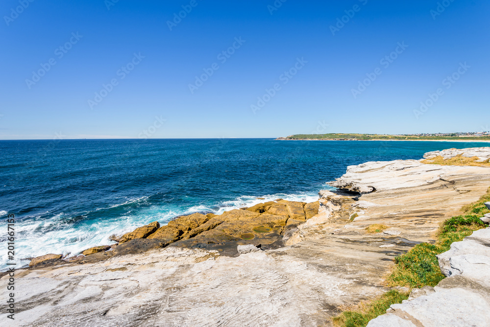 Sunny beautiful summer coast view to the blue Tasman Sea with wild wave water and rocky sharpe cliffs at shore perfect for fishing and hiking, swiming dangerous, Sydney, NSW, Maroubra Beach, Australia Sunny beautiful summer coast view to the blue Tasman Sea with wild wave water and rocky sharpe cliffs at shore perfect for fishing and hiking, swiming dangerous, Sydney, NSW, Maroubra Beach, Australia