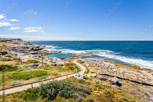 Fototapeta Naklejka Na Ścianę i Meble -  Sunny beautiful summer coast view to the blue Tasman Sea with wild wave water and rocky sharpe cliffs at shore perfect for fishing and hiking, swiming dangerous, Sydney, NSW, Maroubra Beach, Australia