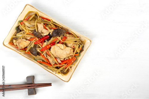 top view of stir fried chicken with ginger and vegetable in a ceramic plate on white wooden background, copy spce. homemade style hot and spicy food menu.