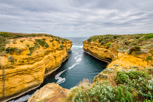 Cloudy sunny summer coast view to a beautiful sandy beach bay and rocky erosion sand limestone cliff of Great Ocean Road, walking at Loch Ard Gorge, Port Campbell National Park, Victoria/ Australia