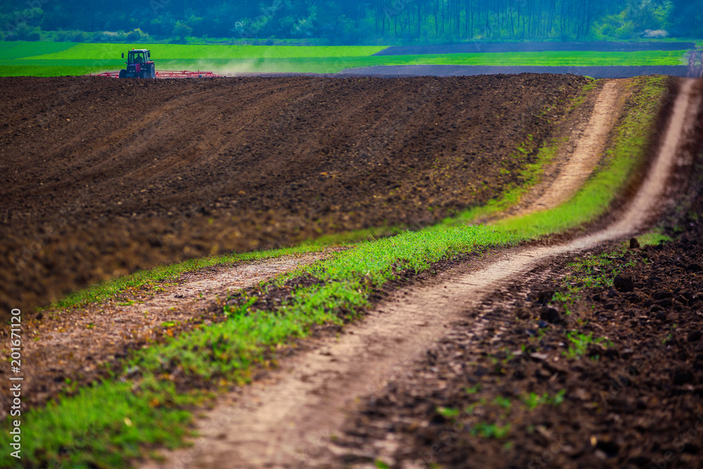 Farmer with tractor seeding crops at field Farmer with tractor seeding crops at field