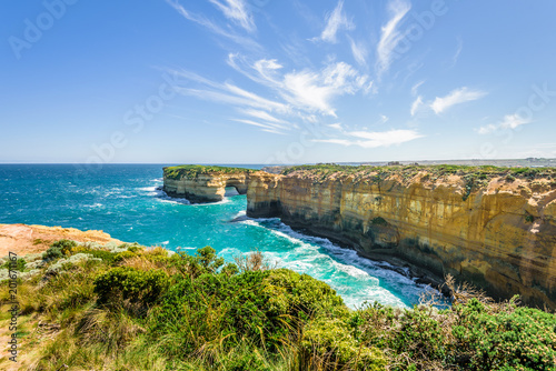 Bright sunny summer coast view to a beautiful sandy beach bay and rocky erosion sand limestone cliff of Great Ocean Road, walking at Loch Ard Gorge, Port Campbell National Park, Victoria/ Australia
