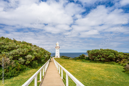 Sunny beautiful summer coast view a white bright light station at Otway National Park with green area and the blue waves of the Bass Strait sea, Cape Otway Lighthouse, Victoria, Melbourne, Australia photo