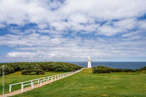 Sunny beautiful summer coast view a white bright light station at Otway National Park with green area and the blue waves of the Bass Strait sea, Cape Otway Lighthouse, Victoria, Melbourne, Australia © Thomas Jastram
