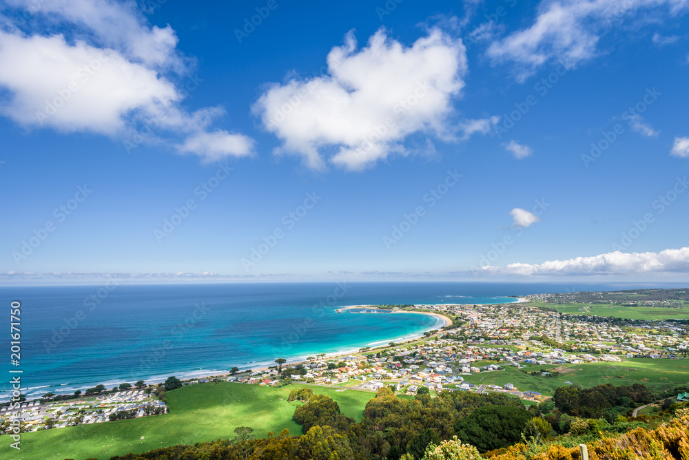 Relaxing at the blue Bass Strait sea and enjoying a warm sunny beach view over blue sky water of Great Ocean Road with a few clouds horizon over small town Apollo Bay, Melbourne, Victoria, Australia