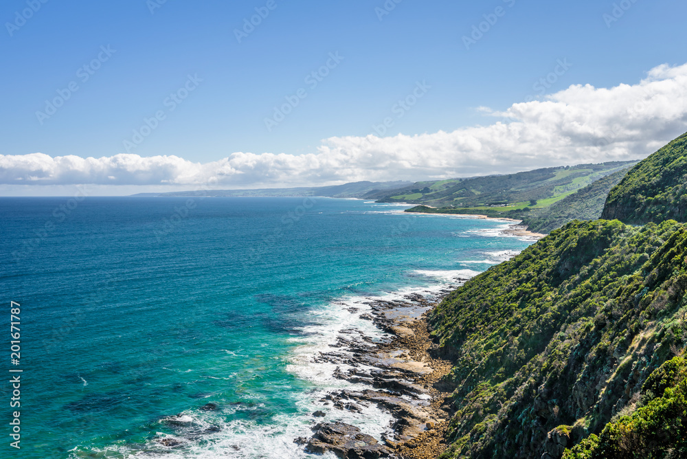 Relaxing at the blue Bass Strait sea and enjoying a warm sunny beach view over blue sky water of Great Ocean Road with a few clouds horizon over small town Apollo Bay, Melbourne, Victoria, Australia