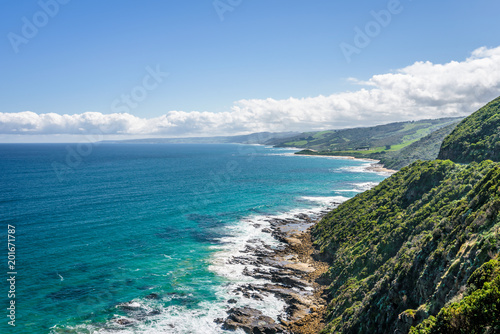 Relaxing at the blue Bass Strait sea and enjoying a warm sunny beach view over blue sky water of Great Ocean Road with a few clouds horizon over small town Apollo Bay, Melbourne, Victoria, Australia